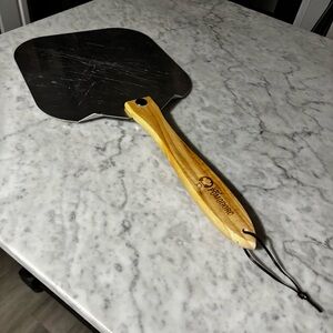 Pomodoro-branded wooden spatula and a metal pizza peel.